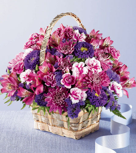 Brilliant Meadow Basket - arrangement of pink and purple flowers in a light brown basket.