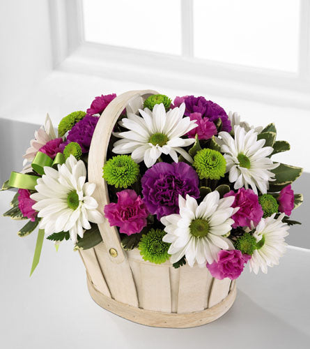 Blooming Bounty Bouquet - Floral arrangement in a basket with white, purple, and green flowers.