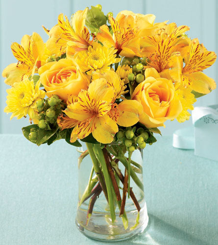 Sunny Day Bouquet - arrangement of yellow flowers in a clear vase.