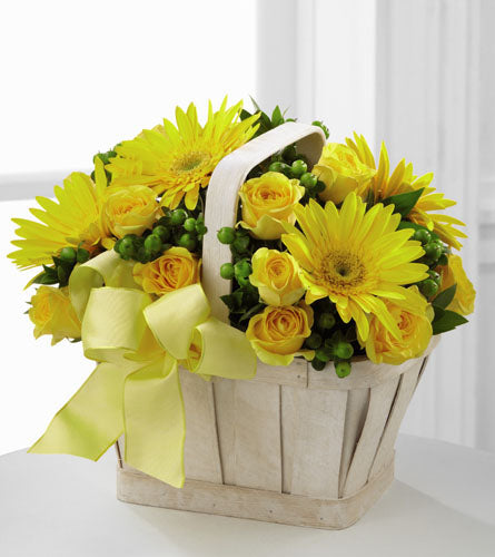 Uplifting Moments Arrangement - floral arrangement with yellow flowers and greenery in a white basket with yellow bow.