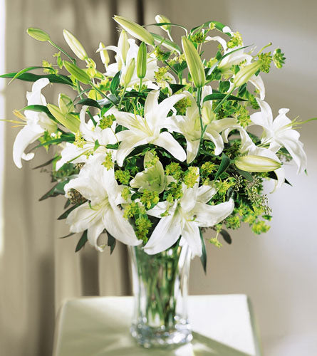 Lilies & More Arrangement - Bouquet of white lilies and greenery in a clear vase.