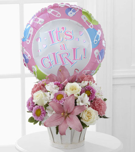 FTD's Girls Are Great! Arrangement - Pink and white floral arrangement in a white basket with a 'It's a Girl!' balloon attached.