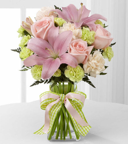 FTD's Girl Power Bouquet - arrangement of pink and green flowers arranged in a clear vase tied with a decorative bow.
