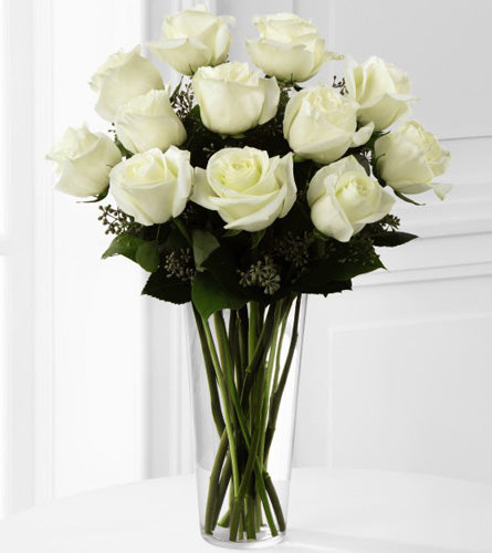 White Rose Arrangement - bouquet of a dozen white roses with greenery in a clear vase.