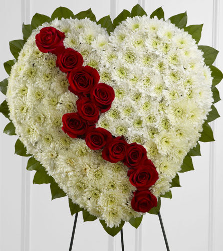 Broken Heart - heart-shaped arrangement of white flowers and twelve red roses on a stand.