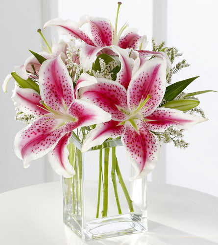 Pink Lily Bouquet - floral arrangement of pink and white lilies in a clear vase.
