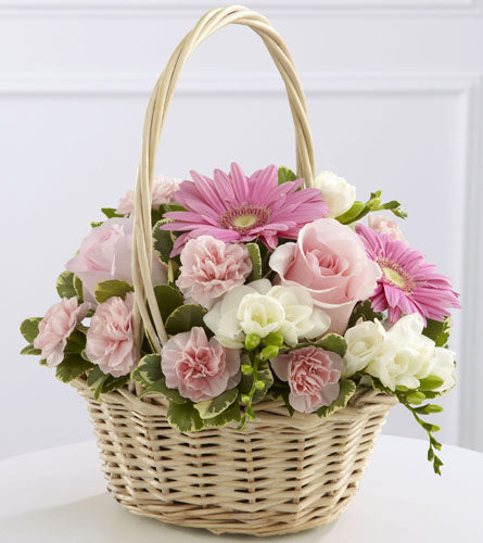 Enduring Peace Bouquet - wicker basket filled with pink gerbera daisies, roses and mini carnations accented with lush greens.