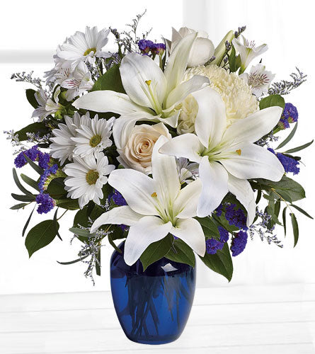 Beautiful in Blue - Bouquet of white lilies, roses, and daisies in a blue vase.