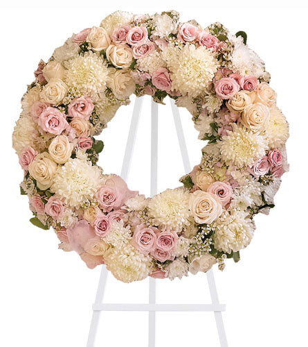 Peace Eternal Wreath - floral wreath with pink and white flowers on a white stand.