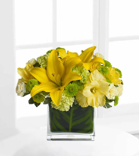 Oh Happy Day by Teleflora - floral arrangement with yellow and green flowers in a clear glass cube.