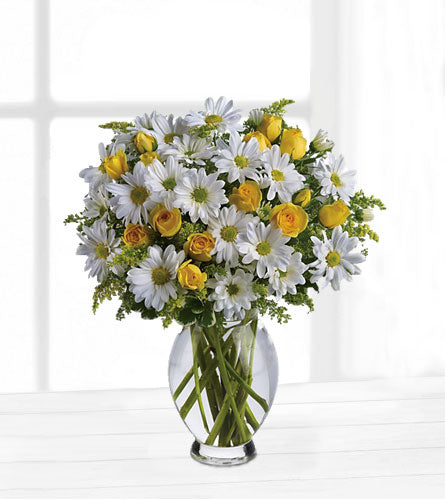 Teleflora's Amazing Daisy - bouquet of white daisies and yellow spray roses in a clear vase.