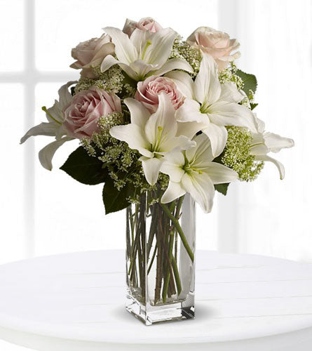 Heavenly & Harmony Arrangement - Bouquet of white lilies and pink roses in a clear vase.