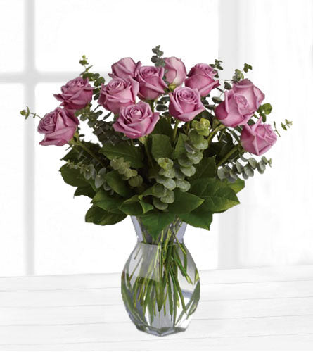 Lavender Wishes - Bouquet of twelve lavender roses with eucalyptus and greenery in a clear vase.