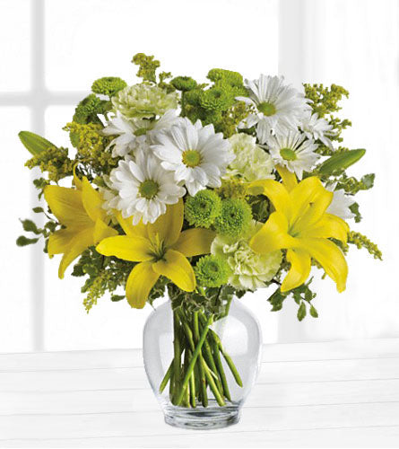 Brightly Blooming - Bouquet of yellow and white flowers in a clear vase.