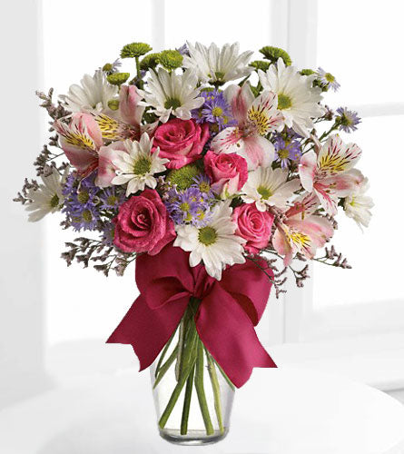 Pretty Please - Bouquet of flowers with pink roses and white daisies in a clear vase with a pink ribbon.