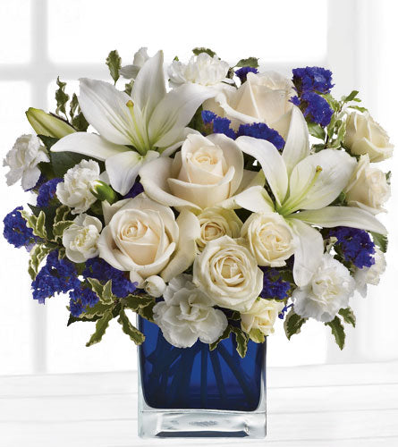 Sapphire Skies Bouquet - white and blue flowers arranged in a blue cube vase.