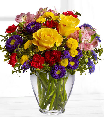 Brighten Your Day - colourful arrangement in a clear glass vase.