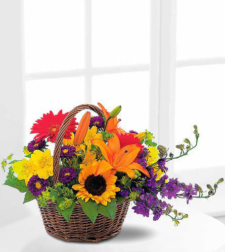 Teleflora's Basket of Blooms - colourful flower arrangement in a dark brown wicker basket.