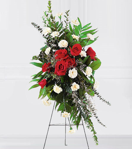 Remembering Forever - floral arrangement with red roses, white carnations and greenery on a stand.