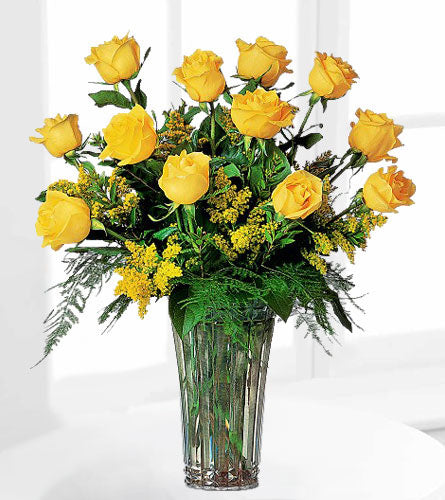 A Dozen Yellow Roses - bouquet of twelve yellow roses with greenery in a clear vase.