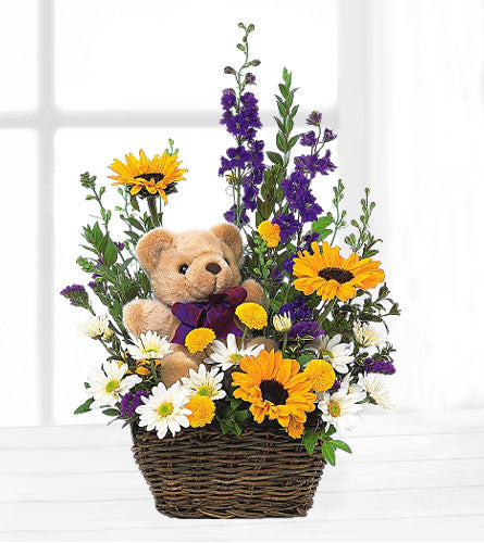 Basket and Bear Arrangement - bouquet of flowers with a teddy bear in a dark brown woven basket.