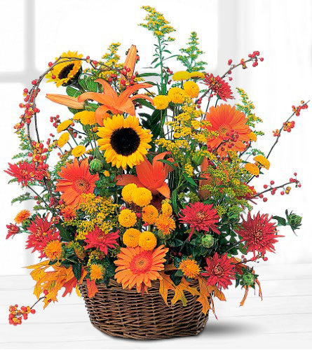 Teleflora's Majestic Fall - arrangement of colourful flowers in a brown wicker basket.