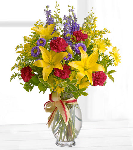 Sunny Side Arrangement - Bouquet of colorful mixed flowers in a clear glass vase.