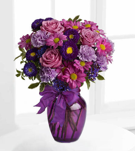 Everlasting Lavender - bouquet of purple, blue and pink flowers in a purple glass vase.