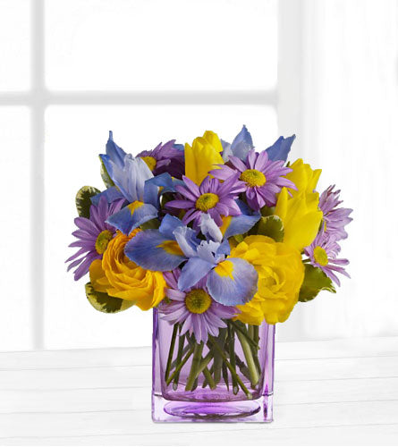 Spring Sunlight - Bouquet of purple daisies, yellow roses and blue iris in a clear glass vase.