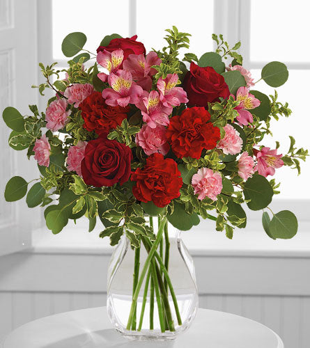 Blooming Belles in a Clear Vase - Bouquet of red and pink flowers in a clear vase.