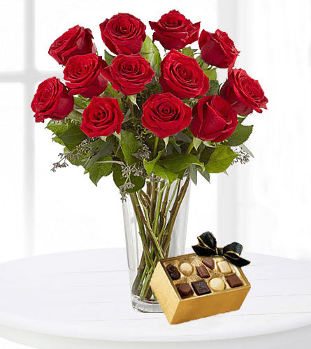 A Dozen Red Roses with Large Chocolates - twelve red roses in a clear vase with a large box of chocolates.