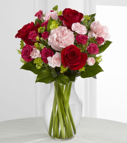 Love is Grand Bouquet - red roses, hot pink spray roses and light pink carnations with greenery in a clear glass vase.