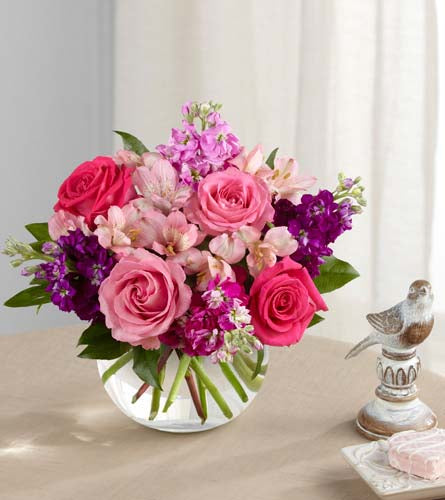 FTD's Tranquil Bouquet - pink and purple flowers arranged with greenery in a clear bubble bowl vase.