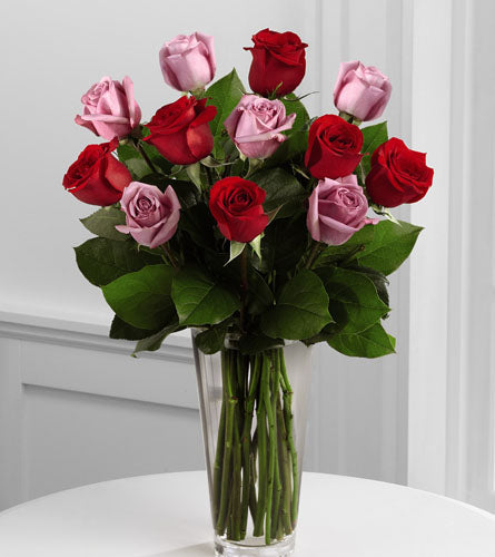 Red and Lavender Rose Bouquet - arrangement of twelve red and pink roses in a clear glass vase.
