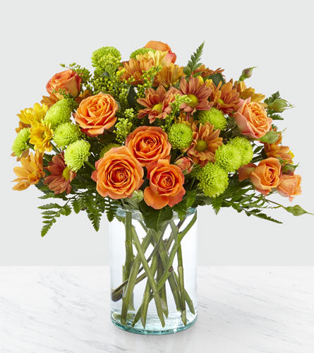 Autumn Delight - bouquet of orange and green flowers in a clear glass vase.