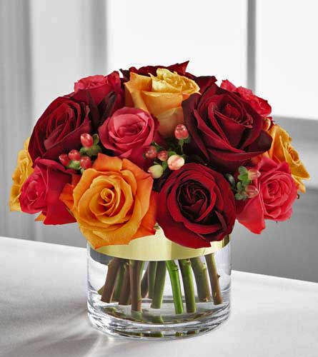 Autumn Passages Bouquet - arrangement of red and yellow roses in a clear vase.