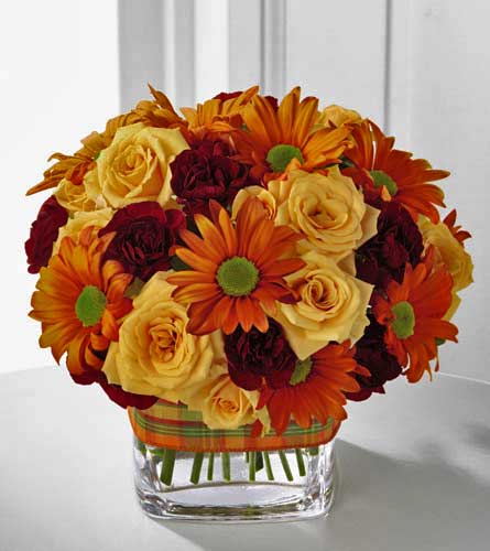 FTD's Golden Autumn Bouquet - arrangement of autumn orange, yellow and red flowers in a clear glass vase.