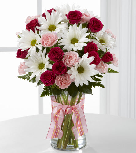 Sweet Surprises with Hot Pink Spray Roses - bouquet of red and pink mini carnations, with daisies in a clear vase with a pink bow.