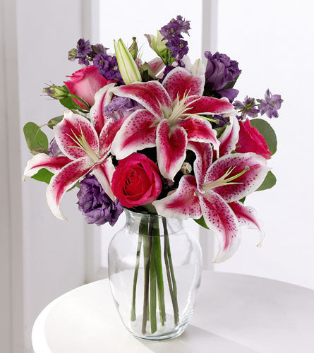 FTD's Bright & Beautiful Arrangement - Bouquet of pink, red and purple in a clear vase.