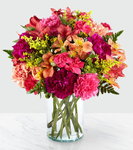 All is Bright in a Clear Vase - Arrangement of brightly coloured flowers placed in a clear glass vase.