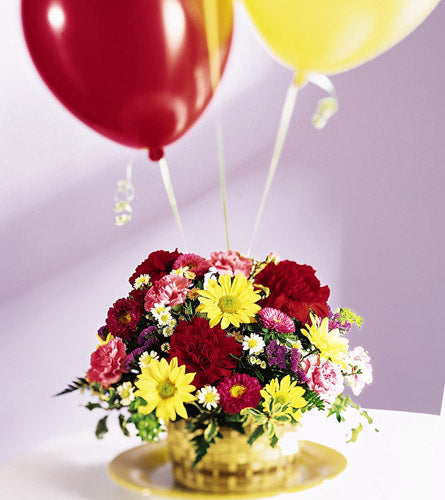 Let's Be Buds Arrangement - woven basket of colourful flowers with red and yellow latex balloons.