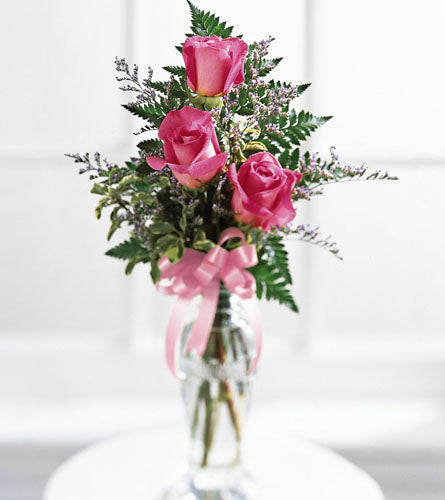 Triple Delight Rose Bouquet - arrangement of three pink roses with greenery in a clear vase with a pink bow.