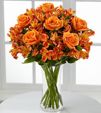 Orange Burst Bouquet - floral arrangement orange roses, lilies and alstroemeria in a clear vase.
