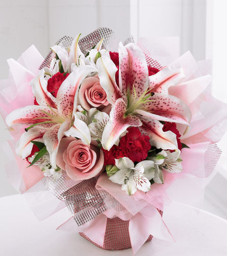 Starshine Bouquet - floral arrangement of red, white and pink flowers in a pink wrapped cube.