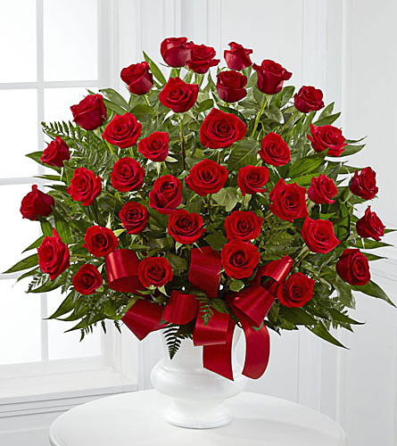 Souls Splendour Arrangement - bouquet of thirty six red roses with green leaves on a white pedestal with a red bow.