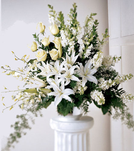 Light In Your Honour Arrangement - bouquet with white and yellow flowers on a white pedestal.