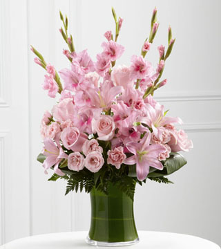 Lovely Tribute - pink arrangement in a green container.