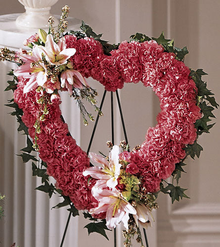 Our Love Eternal Heart - floral heart shaped wreath with pink flowers and green leaves on a stand.