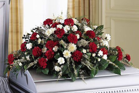 Sincerity Casket Spray - Floral arrangement with red and white flowers with greenery.