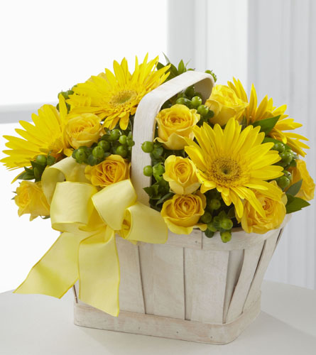Uplifting Moments Bouquet - arrangement of yellow flowers in a white basket with a yellow ribbon.